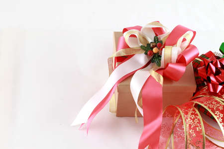 Brown paper gift box with red ribbon bow, isolated on whiteの写真素材