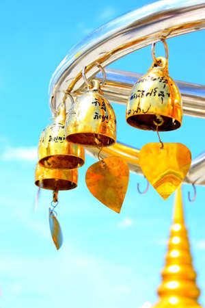 The bell hang on the tree that grow in temple area 