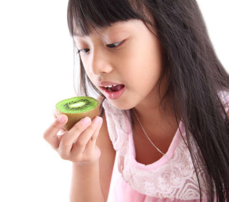 Young girl eating a kiwiの写真素材