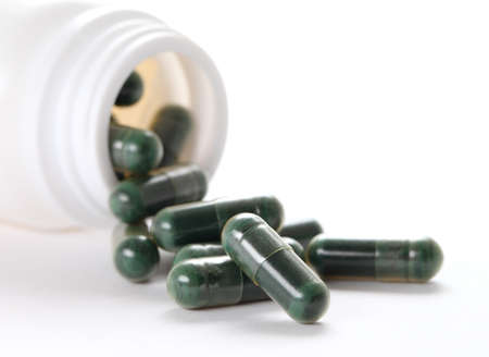 Capsule pills on white background, green capsule pills
