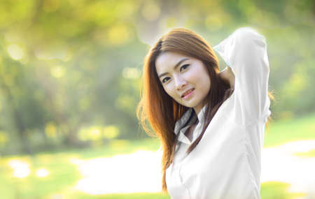 Beauty Romantic Girl Outdoors. Beautiful Teenage Model girl in White Dress on the Field in Sun Light. Blowing Long Hair. Autumn. Glow Sun, Sunshine. Backlit. Warm colorsの写真素材