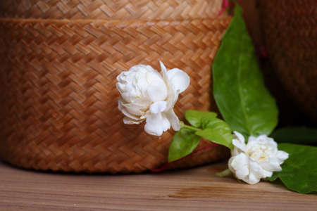 Jasmine flowers and leaves on brown wooden board.の写真素材