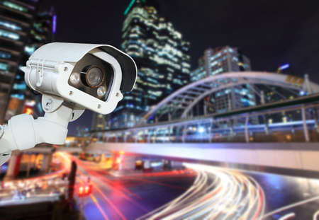 CCTV camera with blurring the night city in background.の写真素材