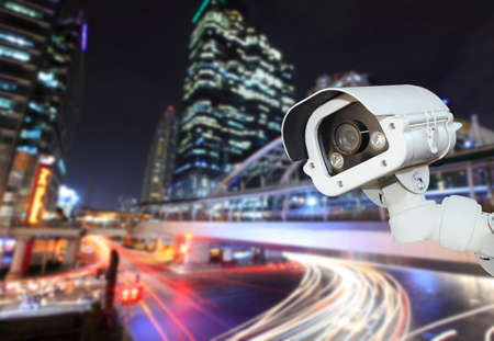 CCTV camera with blurring the night city in background.の写真素材