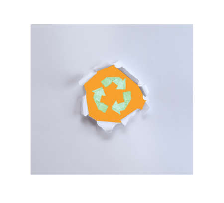 Hole in the paper with torn sides.Recycle logo on old paper.の写真素材