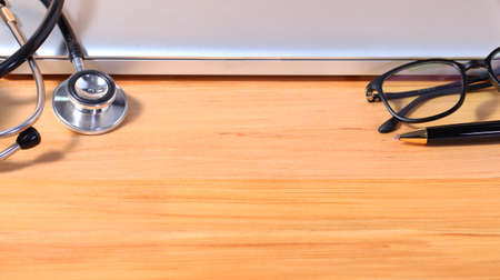 Studio macro of a stethoscope pen eyeglass and notebook with shallow DOF evenly matched abstract on...