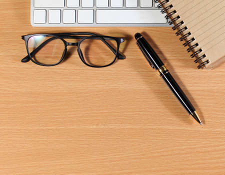 laptop and glasses, pen and notebook on wooden table,の写真素材