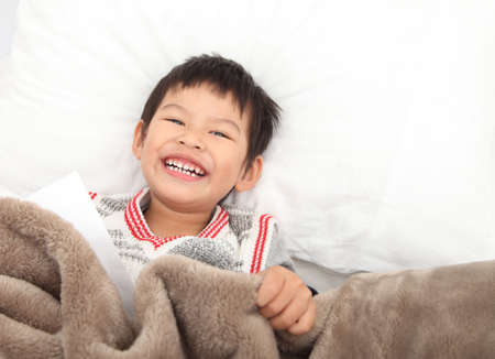 Asian young child wakes up in the morning in the bedroom.の写真素材