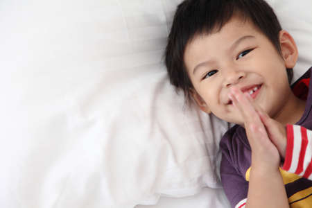 Asian  boys wake up and smiling morning on the couch.Child waking up in the morning smiling and happy.の写真素材