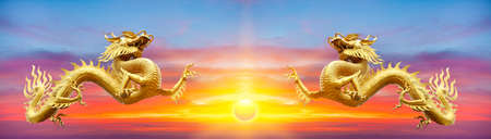 Couple golden dragon on sunset background.Golden chinese dragon on dramatic twilight with blue sky cloud at sunset.Copy space background.の写真素材