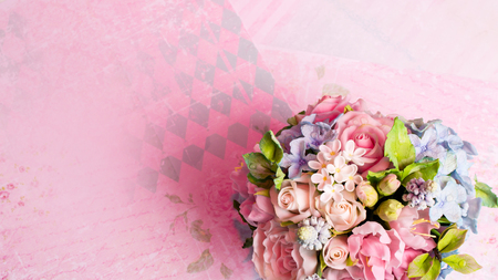 a bouquet of flowers on a pink background in style shabby chicの写真素材