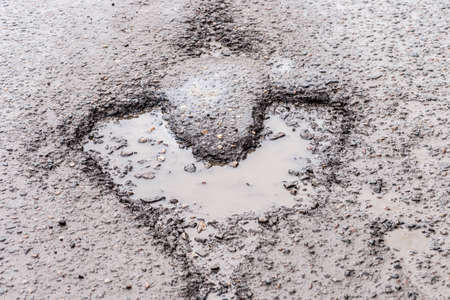 the pothole in the road in the shape of a heartの写真素材