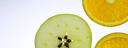 three orange and apple slices on white backgroundの写真素材