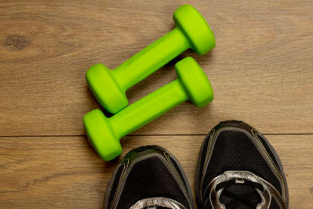 fitness lifestyles concept, dumbbells, sport shoes on wood background top viewの写真素材