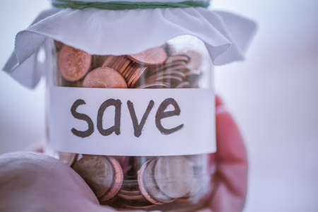 glass jar with coins and the inscription saveの写真素材