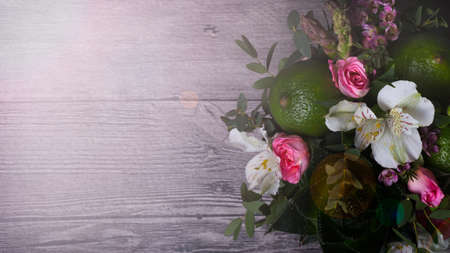 bouquet of roses, limes, aloe and alstromeria on wooden deskの写真素材