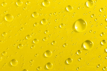 Water droplets on yellow glass backgroundの写真素材