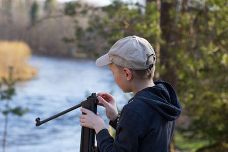 teenager with air gun in forestの写真素材