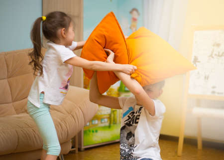Happy family. Sister and brother are playing on the floor at home. Young boy and lovely girl having fun in children room.の写真素材