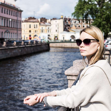 Shot of a beautiful woman standing a small bridge over the canal while on sightseeing in a foreign city.の写真素材