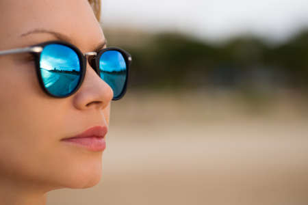Blue mirror sunglasses sexy woman beauty at the beach. Travel vacations concept.の写真素材