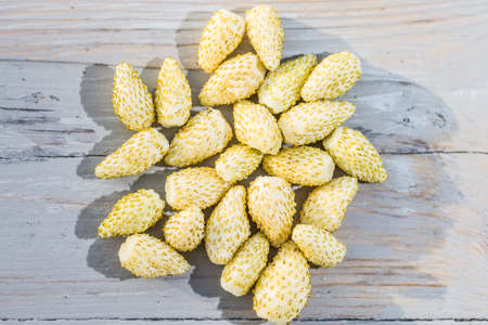 White wild strawberries on a wooden table natural backgroundの写真素材