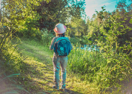 Traveler young girl with backpack walking on path in the tropical forestの写真素材