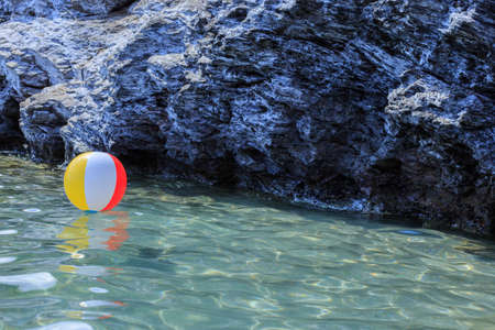 Large colorful beach balls on the water in the sea by the beach. Holidays, travel, vacation and happiness concept.の写真素材