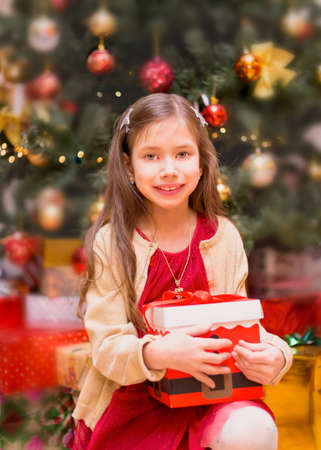 Happy little smiling girl with christmas gift box.の写真素材