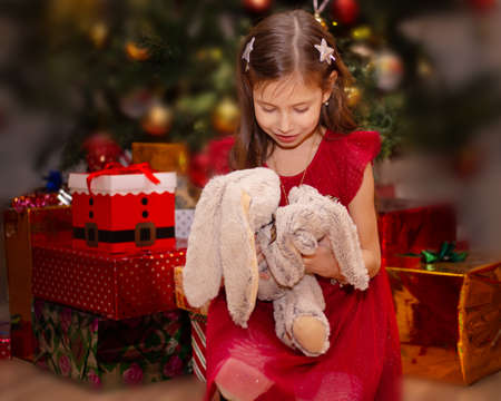Happy little smiling girl with christmas gift.の写真素材