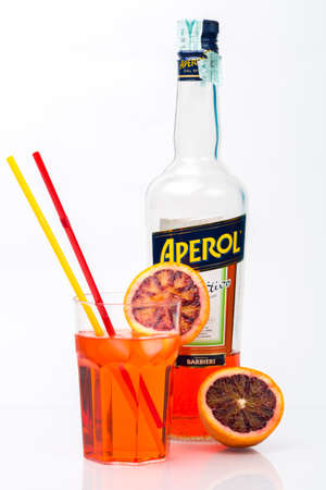 TRIESTE, ITALY, March, 9, 2016; Glass of light drink and ice cube with bottle of Aperol, Aperitivo Poco Alcolico, Liqueur alc.11%. Famous Italian aperitif. Produced by Fratelli Barbieri S.P.A., Italyのeditorial素材