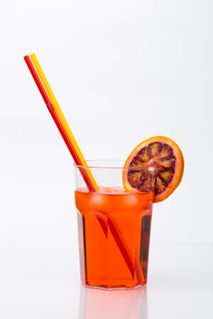 Aperol spritz aperitif alcoholic cocktail with orange slices and ice cubes isolated on white backgroundのeditorial素材