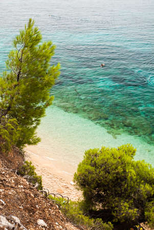 BOL,BRAC,CROATIA - AUGUST 3: Crowded beach of Zlatni Rat and village pier on August 03, 2014 in Bol, Croatia. Bol is one of the most famous tourist desinations on the adriatic islands.のeditorial素材