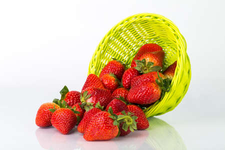 Fresh red strawberries in a wooden bowl isolated on a whiteの写真素材