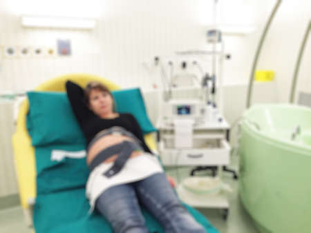 Blurred image of pregnant patient in hospital bed for background usage.の写真素材