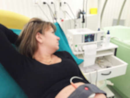 Blurred image of pregnant patient in hospital bed for background usage.の写真素材