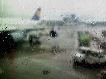 Blurred abstract background : airplane wing at airport, window with rain dropsの写真素材