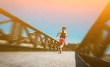 Abstract motion blur:  Young woman jogging cross-country running in summer seaside.  Concept fitness and healthy lifestyleの写真素材