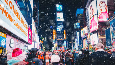 New York City, USA - March 18, 2017: People and famous led advertising panels in Times Square during the snow, one of the symbol of New York City.