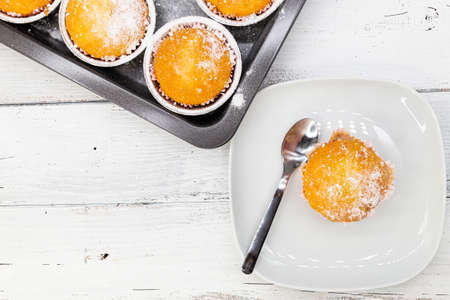 Set of assorted fresh baked vanilla muffins on white rustic wooden table, top viewの写真素材
