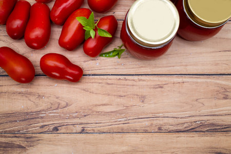 Top view of traditional Italian tomato sauce in a glass jar with fresh tomatoes and basil. Copy space.の写真素材