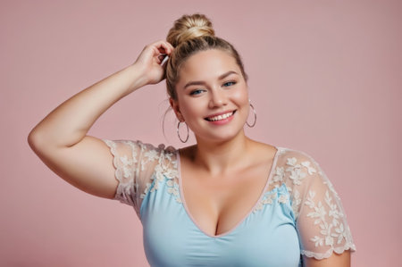 A woman with blonde hair tied in a bun, wearing a blue shirt with white lace details. She has hoop earrings and is smiling. Self-acceptance and body positivity conceptの素材
