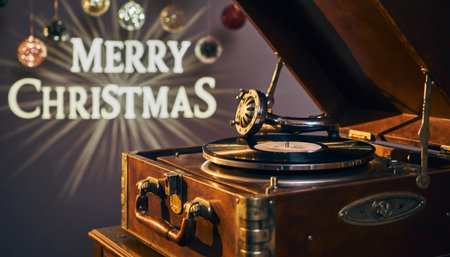 Vintage turntable playing music in warm holiday setting with illuminated Christmas text and decorative baubles. Perfect for seasonal marketing, nostalgia campaigns, and festive content.の素材