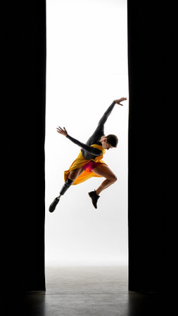 Inspiring athlete with prosthetic limb performs expressive dance jump in minimalist studio setting. Perfect for diversity campaigns, adaptive sports marketing, and inclusionの素材