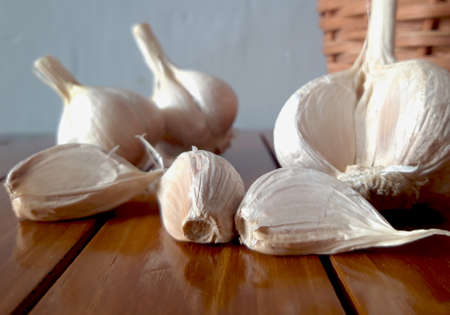 Healthy and wholesome food. Fresh garlic in a wicker basket on a wooden table