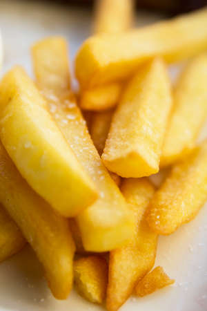 Crispy slices of french fries sprinkled with saltの写真素材