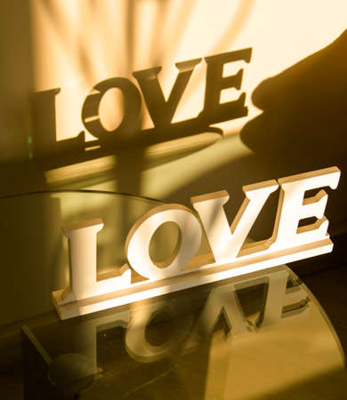 inscription love with reflection and shadow on the wallの写真素材