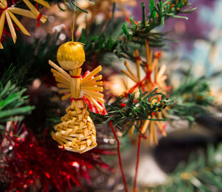 Toy straw angel on the Christmas tree branchの写真素材