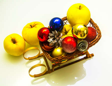 Wicker basket sleigh with Christmas decorations and applesの写真素材