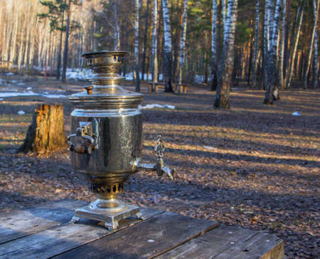 first spring tea from a samovar in the woods with melted snowの写真素材